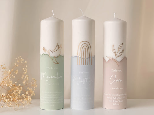 Frontansicht von drei Taufkerzen mit verschiedenen Taufmotiven und den drei Farben, grün, beige und blau